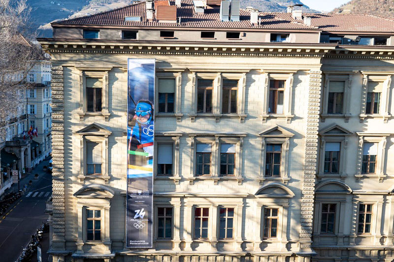 Ein Banner für Olympia: Seit dem 3. Februar schmücke ein Banner die Fassade des Palais Widmann und erinnert daran, dass in einem Jahr die Winterspiele 2026 auch in Südtirol stattfinden. (Foto: LPA/Fabio Brucculeri)